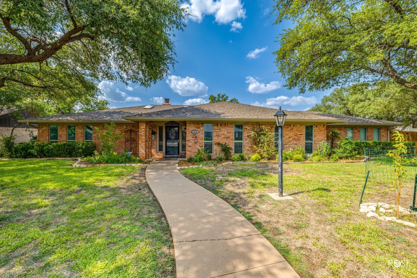 Brick ranch home shaded by mature oaks in San Angelo