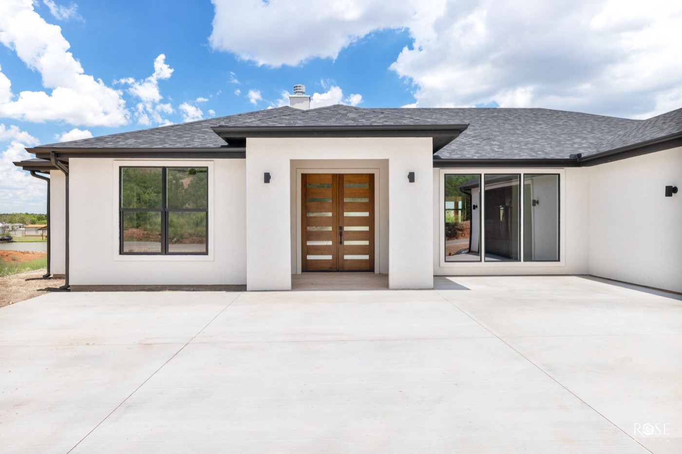 White stucco home entry with wood doors in The Bluffs, San Angelo